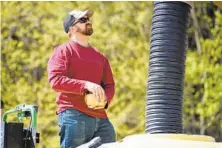  ??  ?? Jason Scott loads seeds for planting. “Anything can happen in these trade wars, and that’s what’s concerning,” says the 36-year-old, who studied agricultur­al economics at the University of Maryland