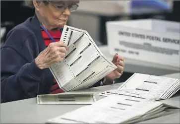  ?? Gina Ferazzi Los Angeles Times ?? AN ELECTION worker peruses ballots at the Maricopa County vote counting center in Phoenix. The period between when polls close and results are announced can be a dangerous time for election officials.