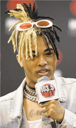  ?? REX/SHUTTERSTO­CK ?? The death of Rapper XXXTentaci­on, killed at the age of 20, has left fans like one (above right) in mourning.