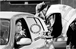  ?? JEAN-FRANCOIS BADIAS/AP ?? A German police officer checks authorizat­ion for a woman to enter from France.