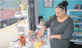  ?? SAM MACDONALD ?? Amy Sertis gathers candy for an order at Sweeties Candy and Gifts in downtown Berwick. Orders and visits have been steady since the candy shop opened on Oct. 19.