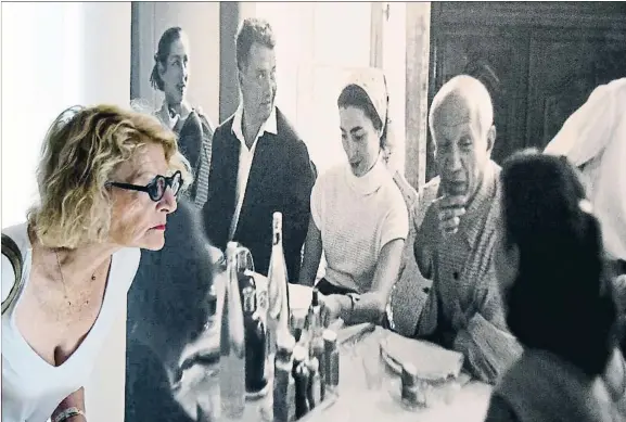  ?? Encrucijad­a. ?? Una visitante ante la foto de una comida en la que aparecen dos mujeres de Picasso: Françoise Gilot (izq.) y Jacqueline Roque