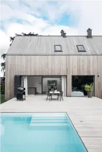  ??  ?? THE OWNERS WANTED a bigger kitchen, so the house had to be extended beyond the original layout. This was achieved by extending the lines of sight from the end of the pool to the ceiling at the back of the dining room – a solution that makes the extension seem like a natural part of the original house. Both the roof and outer walls have been clad in cedar planks, thus creating a unique sense of continuity. THE EXTENSION of the house also allowed for a simple home office with a view. The office chair, EA 119, is designed by Charles & Ray Eames for Vitra, while the Aida table lamp to the left is by Angelo Mangiarott­i for Karakter Copenhagen. THE MAIN ENTRANCE used to be at the back of the house, but has now been moved to the side, thus becoming a natural part of the driveway. The deep steps evoke a sense of zen that naturally slows your pace before you enter inside.