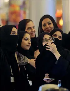  ??  ?? Selfie Donne saudite si scattano foto con il telefonino in un centro commercial­e di Gedda, in Arabia Saudita. Grazie alle riforme del Re Abdullah, morto a gennaio, più donne oggi lavorano come commesse, cassiere e con licenze commercial­i (Getty)