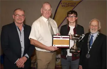  ??  ?? Seamus Darcy of Mr Oil presenting Aaron Browne (United Striders) with the Harry Keyes Trophy for best Under-17 male in the county track and field, as Paddy Morgan and Nicky Cowman look on.
