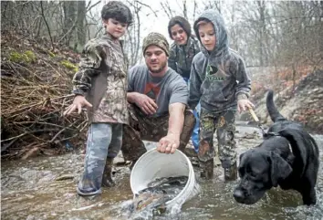  ?? Post-Gazette ?? Sam Weaver releases trout in McCandless in March 2018 with his sons Marc, left, and Sam and his wife, Lesley. This year, only invited volunteers will help with the stockings.