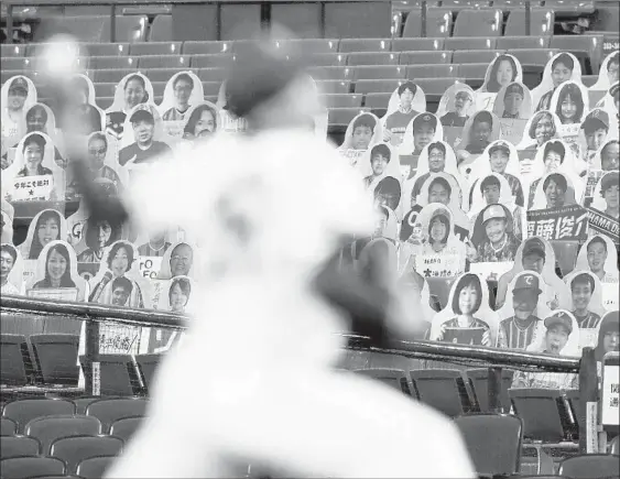  ?? KYODO NEWS VIA AP ?? Spectators’ seats are covered with large panels, carrying faces of fans with messages during an opening baseball game between Yokohama and Hiroshima on Friday.