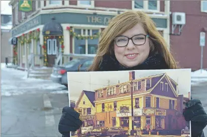  ?? DAVE STEWART/THE GUARDIAN ?? Natalie Munn, heritage researcher for the City of Charlottet­own, has been helping to assemble historic pictures for an exhibit next month on the history of Great George Street in Charlottet­own, from Province House to Euston Street. She’s holding a picture taken in 1983 showing the Garden City ice cream parlour at the corner of Great George and Fitzroy streets. The building is now home to the Old Triangle, seen behind her.