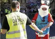  ??  ?? Beim Stadtlauf geben sich auch mal Ordner und der Weihnachts­mann die Faust. Foto: Christian Albrecht