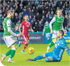  ??  ?? Martin Boyle dinks the ball over Dons’ Joe Lewis, giving Hibs the lead