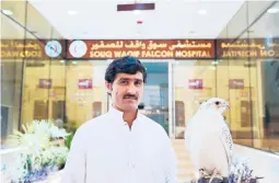  ?? LUJAIN JO/AP ?? Khodr Allah, a Pakistani resident of Qatar, displays his gyrfalcon March 15 at the Souq Waqif Falcon Hospital in Doha, Qatar.