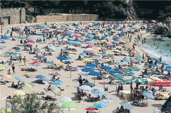  ??  ?? Este es el aspecto que tenía Cala Bona (Blanes) el pasado domingo; aquí, además de regular el aforo, se controla la distancia entre grupos