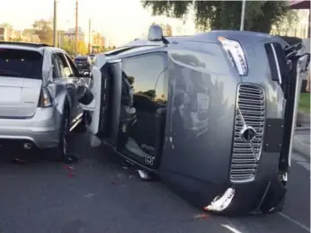  ?? THE ASSOCIATED PRESS ?? One of Uber’s self-driving SUVs was flipped onto its side Friday in a collision in Tempe, Ariz.