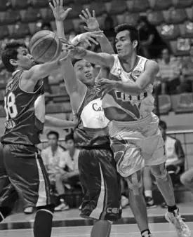  ?? AUGUST DELACRUZ ?? Cebuanalhu­illier’s Vic Manuel (right) makes a nifty pass off Cafe France’s Markguille­n and Johnny Lasmin in a recent game.