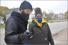  ??  ?? Rick (left) and Yolanda Williams stand on the side of Auburn Road in Pontiac as they complete a mural designed to create community conversati­on around the 2020 election.