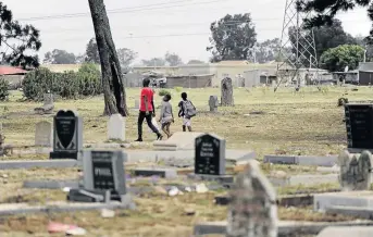  ??  ?? The graves in Tshepiso are not fenced off. People roam around the graves and drug users use the gravesite as their meeting place.