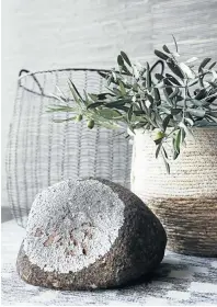  ??  ?? A rock found on the farm displays a lichen that complement­s the home’s interiors, while the basket holds olive branches from Cornel’s parents’ garden.
