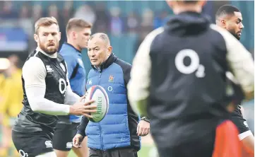  ??  ?? England’s coach Eddie Jones (centre) watches his team warm up before the internatio­nal rugby union test match between England and Australia at Twickenham stadium in south-west London. — AFP photo