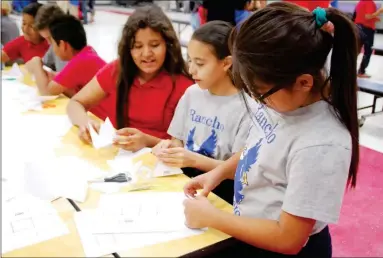  ??  ?? FIFTH-GRADE STUDENTS AT RANCHO VIEJO ELEMENTARY
SCHOOL Kiara Perez (in glasses in photo above), Guadalupe Hernandez and Arianna Cordova fold paper to make various structures during a visit from the Arizona Science Center’s “sciencemob­ile” to the...