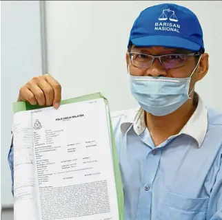  ??  ?? Lim showing the police report he lodged at the Penang MCA headquarte­rs after losing RM500,000 to scammers. Duped: