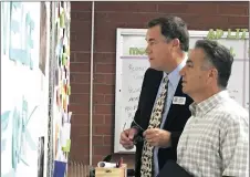  ?? Gina Ender/The Signal ?? Jim Backer and Chris Fall read notes on an encouragem­ent wall at Hart High School for the SCV Education Foundation’s Principal for a Day event on Friday.