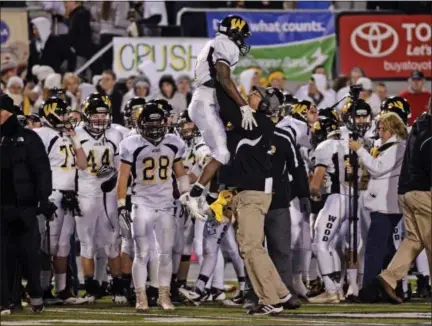  ?? ASSOCIATED PRESS FILE ?? Archbishop Wood’s Jarrett McClenton is met by a coach on the sidelines after during the 2013PIAA Class 3A championsh­ip game against Harrisburg’s Bishop McDevitt in Hershey. Wood’s repeated trips to the PIAA title game — and four titles in the last six...