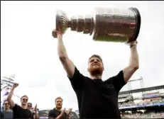  ?? ?? Avalanche forward Nathan Mackinnon hoists the cup at Coors Field on Wednesday night, where the team was honored before the game.