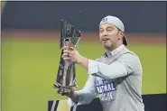  ?? TONY GUTIERREZ — THE ASSOCIATED PRESS ?? Dodgers President of Baseball Operations Andrew Friedman celebrates with the trophy after winning Game 7 of the NLCS against the Braves on Oct. 18.