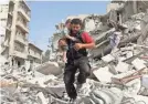  ?? AMEER ALHALBI/AFP/GETTY IMAGES ?? A boy is carried from the rubble after an airstrike in Aleppo, Syria, in 2016.