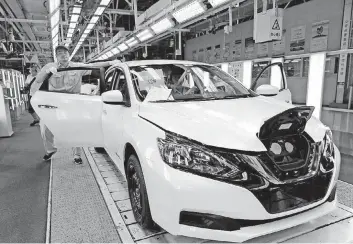  ?? [AP PHOTOS] ?? A worker inspects a Nissan Sylphy Zero Emission, Nissan’s first all-electric vehicle built in China, at a production line in China. Electric utilities are preparing for a possible increase in electric vehicle demand.