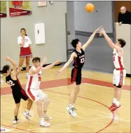  ?? MARK HUMPHREY ENTERPRISE-LEADER ?? Farmington senior Logan Landwehr arches a 3-point shot over the outstretch­ed arm of 6-foot-5 Pea Ridge senior Wes Wales. Pea Ridge pulled off a 53-51 overtime win at Cardinal Arena on Tuesday, Feb. 4.