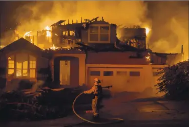  ?? DAI SUGANO — STAFF PHOTOGRAPH­ER ?? A firefighte­r hoses down a burning home to help stop the spread of fire to nearby homes in the Skyhawk community as the Shady Fire burns in Santa Rosa on Monday.