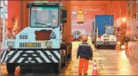  ?? YANG JIANGQI / XINHUA ?? Workers transfer cargo under a bridge crane at Ningbo Zhoushan Port in Zhejiang province in December.