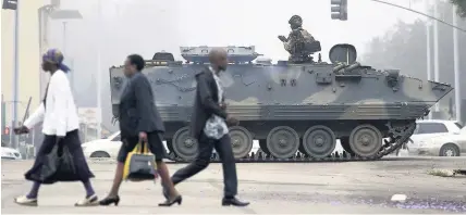  ??  ?? > An armed soldier patrols a street in Harare, Zimbabwe, yesterday. Zimbabwe’s army has President Robert Mugabe and his wife in custody