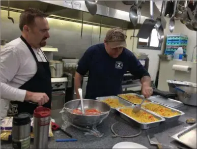  ?? BY GLENN GRIFFITH — THE SARATOGIAN ?? Ed Hersh and Pat Mangini, left and right, in the kitchen of Ballston Spa Union Fire Company No. 2 on Thursday preparing a tray of vegetables for the Ballston Spa Thanksgivi­ng Meal.