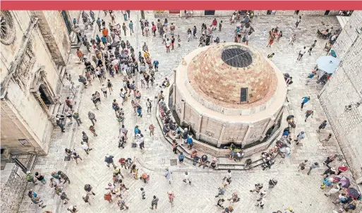  ?? DMITRY KOSTYUKOV PHOTOS THE NEW YORK TIMES ?? People walk on the main street near the entrance to the old town of Dubrovnik, Croatia.