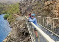  ??  ?? Allan and Paula Wallace take in a view of Lake Benmore from a bridge on the new section of the Alps2Ocean cycle trail.