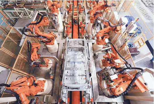  ??  ?? Robots work at a car assembly line. An important functional area for advanced manufactur­ing and producer service in the Shanghai free trade zone, Jinqiao is taking a key step in developing next generation intelligen­t manufactur­ing. — Ti Gong