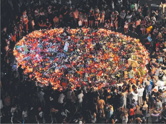  ?? Picture: AFP ?? People pay tribute to the victims of the Barcelona attack on Las Ramblas boulevard in Barcelona at the weekend.