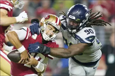  ?? TONY AVELAR — THE ASSOCIATED PRESS FILE ?? 49ers quarterbac­k Jimmy Garoppolo avoids being sacked by Seahawks defensive end Jadeveon Clowney on Nov. 11, 2019.