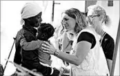  ?? IGOR PETYX/EPA ?? An Italian Red Cross volunteer welcomes a migrant child who was rescued and arrived Friday in Palermo, Italy.