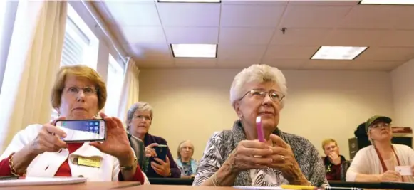  ?? KATHERINE FREY PHOTOS/THE WASHINGTON POST ?? Residents at Westminste­r at Lake Ridge, a senior living community in Prince William County, Va., listen as Christian Magnuson, 16, teaches them to use their smartphone­s.