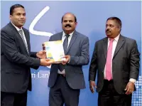  ??  ?? The first print copy being presented to Minister by Kumarasing­he Sirisena