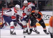  ?? NEWS PHOTO RYAN MCCRACKEN ?? Medicine Hat Tigers captain James Hamblin battles for a loose puck with Lethbridge Hurricanes Logan Barlage (27) and Koletrane Wilson (29) during Saturday's Western Hockey League game at the Canalta Centre.