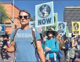  ??  ?? Activists march through downtown Los Angeles during a recent climate change rally.
AFP