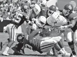  ?? AP Photo/Sue Ogrocki ?? ■ Florida Atlantic running back Devin Singletary (5) is stopped by, clockwise from left, Oklahoma defensive back Justin Broiles (25), defensive end Ronnie Perkins (7), defensive tackle Marquise Overton (97) and defensive end Tyreece Lott (93) on Saturday in Norman, Okla.