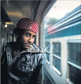  ?? Photo: Nicolas Armer/dpa ?? Escape route: Meron from Eritrea looks out of the window of a train from Rome to Bozen, Italy. Many refugees fleeing hunger, war and persecutio­n in their home countries travel by train from Italy to Germany.