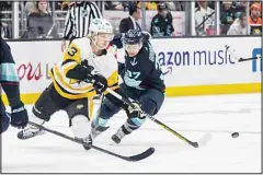  ?? ?? Pittsburgh Penguins forward Danton Heinen (left), and Seattle Kraken forward Yanni Gourde battle for the puck during the second period of an NHL hockey game in Seattle. (AP)