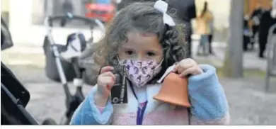  ??  ?? Una niña sostiene una de las campanas de barro frente a Santo Domingo.