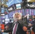  ?? SPENCER PLATT/GETTY IMAGES ?? Traders endure turbulence on the floor of the New York Stock Exchange on Thursday.